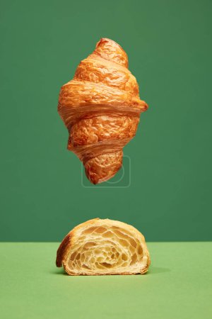 Photo for Perfect. Crispy, fresh croissant, whole and cut in half isolated over green background. Concept of food, bakery, breakfast ideas, taste, freshness. Poser. Copy space for ad - Royalty Free Image