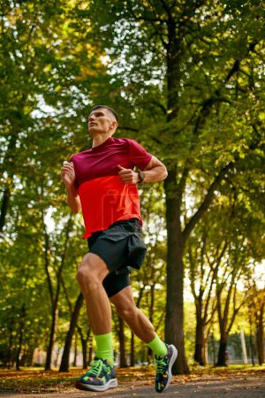 Photo for Dynamic image of man in sportswear, running, athlete in motion, training in city park. Preparation. Concept of sport, active and healthy lifestyle, competition, dynamics, marathon - Royalty Free Image