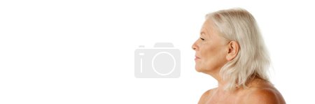 Téléchargez les photos : Image de vue latérale de la femme âgée avec le visage ridé regardant droit sur fond de studio blanc. Bannière. Concept de beauté naturelle, processus de vieillissement, beauté âgée, cosmétologie, soins de la peau - en image libre de droit