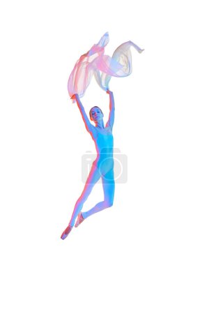 Foto de En un salto. Ligereza. Mujer joven, bailarina de ballet en movimiento, actuando con tela transparente aislada sobre fondo blanco en neón. Concepto de belleza, danza clásica, arte, elegancia, coreografía - Imagen libre de derechos