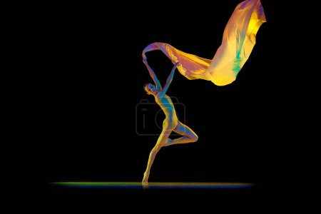 Photo for Beautiful, tender woman, ballerina in bodysuit and pointe dancing with silk fabric isolated on black studio background in neon light. Concept of beauty, classical dance, art, elegance, choreography - Royalty Free Image