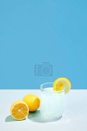 Téléchargez les photos : Rafraîchissements. Cocktail aigre-doux aux citrons et sucre isolé sur fond bleu. Concept de boissons alcoolisées, fête, vacances, mocktails, mix. Affiche. Espace de copie pour la publicité - en image libre de droit