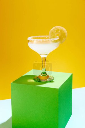 Photo for Sweet and sour, popular margarita cocktail with lemon slice decoration isolated over yellow background. Concept of alcohol drinks, party, holidays, bar, mix. Poster. Copy space for ad - Royalty Free Image
