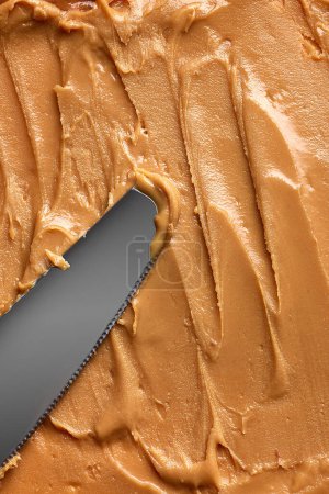 Photo for Close-up of peanut butter with smooth, creamy texture. Light brown color with few small swirls made with knife. Concept of food, breakfast, healthy eating and snacks, organic, homemade products - Royalty Free Image