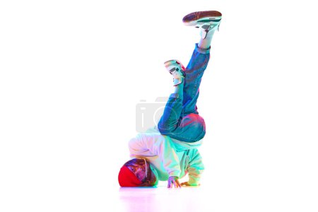 Photo for Flexible yo9ung man in sport clothes dancing hip hop, breakdance isolated over white studio background in neon light. Concept of contemporary dance, street style, fashion, hobby, youth. Ad - Royalty Free Image