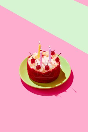 Téléchargez les photos : Délicieux gâteau d'anniversaire avec crème, cerises et bougies brûlantes isolé sur fond multicolore. Concept de nourriture, desserts, fête d'anniversaire, fête. Style pop art. Espace de copie pour l'annonce. Affiche - en image libre de droit