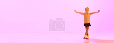 Téléchargez les photos : Belle adorable petite fille, enfant en pull et jupe6, entraînement au patinage artistique, danse sur fond rose au néon. Concept d'enfance, patinage artistique sport, passe-temps, école, éducation - en image libre de droit