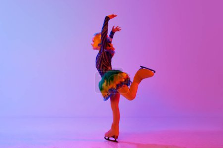 Photo for Cute, talented, little girl, child in stage costume dancing, skating on rink against gradient pink purple background in neon light. Concept of childhood, figure skating sport, hobby, school, education - Royalty Free Image