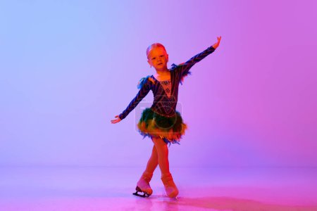 Photo for Beautiful child, little cute girl performing figure skating in cute dress, dancing against gradient pink purple background in neon light. Concept of childhood, figure skating sport, hobby, school - Royalty Free Image