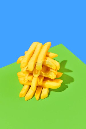 Photo for Crispy, fresh, delicious fried potato, French fries on bright green blue background. Concept of fast food, taste, junk food. Complementary colors. Poster. Copy space for ad - Royalty Free Image