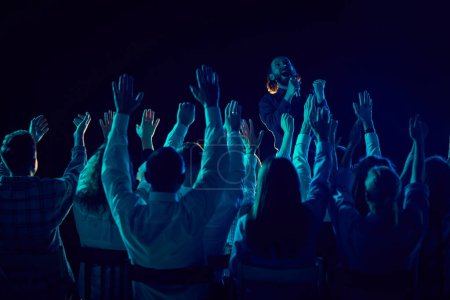 Photo for Group of of different people attending concert, stand up show, cheerfully spending time with jokes and funny stories. Applauding. Concept of entertainment, fun and joy, concert, performance - Royalty Free Image