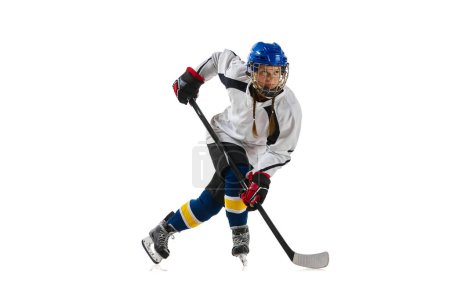 Foto de Chica joven, jugador de hockey profesional en movimiento durante el juego, jugando aislado sobre fondo blanco. Logros. Concepto de deporte profesional, competición, juego, acción, hobby, éxito - Imagen libre de derechos