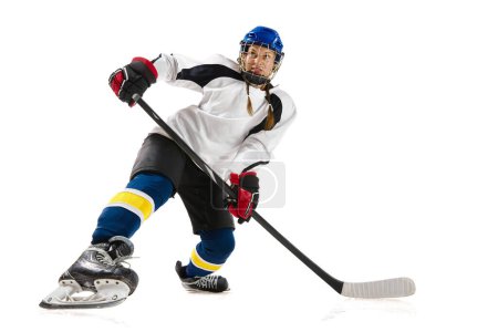 Téléchargez les photos : Jeune fille, hockey jouant dans un casque, uniforme, avec un entraînement de bâton, jouant isolé sur fond blanc. Concept de sport professionnel, compétition, jeu, action, passe-temps, réalisations - en image libre de droit