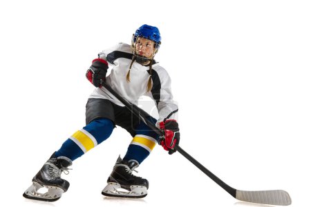 Foto de Chica joven, jugador de hockey profesional en movimiento durante el juego, jugando aislado sobre fondo blanco. Logros. Concepto de deporte profesional, competición, juego, acción, hobby, éxito - Imagen libre de derechos
