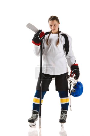 Photo for Young girl, hockey player in uniform standing with stick and posing isolated over white background. Champion. Concept of professional sport, competition, game, action, hobby - Royalty Free Image