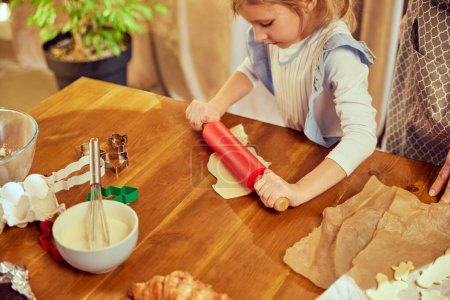 Photo for Top view image with baking items on kitchen table. Little girl, child cooking with her mother, baking croissants and cookies. Concept of cookie day, motherhood, childhood, holidays, family - Royalty Free Image