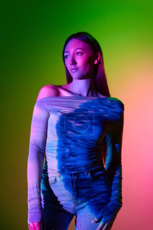 Photo for Portrait of young beautiful girl posing against gradient pink green background with neon reflection. Abstract neon art. Concept of art, modern style, cyberpunk, futurism and creativity - Royalty Free Image