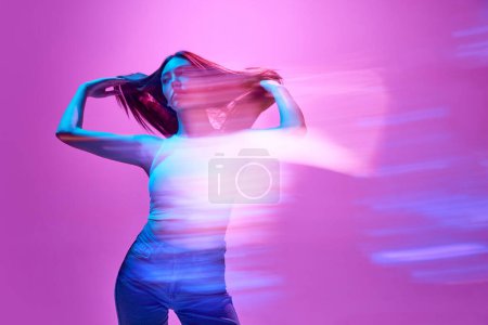 Photo for Portrait of young elegant woman posing against light purple background in neon lights. Silhouette. Lights reflection. Concept of art, modern style, cyberpunk, futurism and creativity - Royalty Free Image