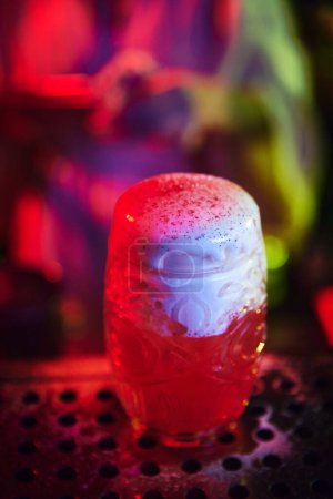 Photo for Glass of delicious sweet long cocktail with sweet foam toppings. Modern neon bar. Concept of occupation, nightlife, bar, party, alcohol drink, mixologist - Royalty Free Image