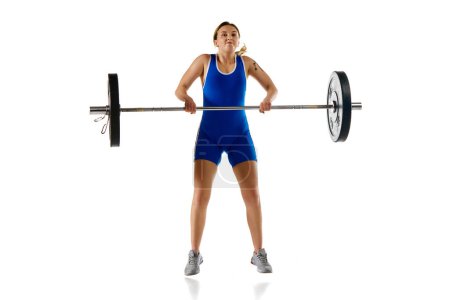 Photo for Young athletic girl, weightlifter training, lifting heavy weight, barbell against white background. Concept of sport, strength, gym, healthy lifestyle, power and endurance, weightlifting. - Royalty Free Image
