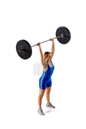 Photo for Top view. Full-length of young athlete, girl training, lifting heavy weights, barbell against white background. Concept of sport, strength, gym, healthy lifestyle, power and endurance, weightlifting. - Royalty Free Image