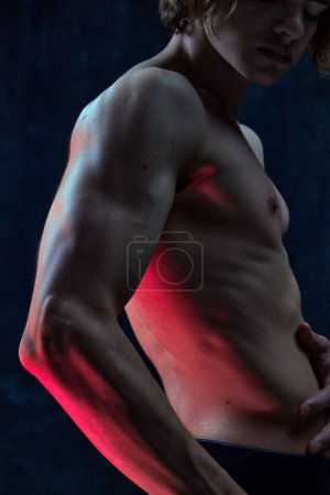 Photo for Cropped image of beautiful male body, muscular torso, hands against dark studio background. Power, strength. Concept of mens beauty, health, body art and aesthetics, care, sportive lifestyle - Royalty Free Image