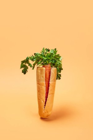 Photo for Carrot placed into bun instead of sausage against orange background. Healthy hot dog. Concept of healthy food, nutrition, diet, organic products, diet, vegetable vitamins. Poster, ad - Royalty Free Image