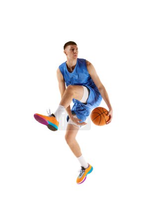 Photo for Dynamic image of young man, basketball player in motion, jumping with ball, scoring winning goal isolated over white background. Concept of sport, competition, match, championship, health, action. Ad - Royalty Free Image