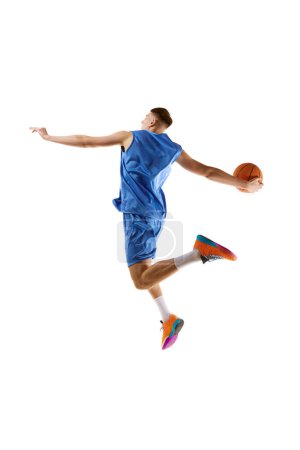 Photo for Slum dunk. Full-length image of young guy, basketball player in motion, jumping with ball isolated over white background. Concept of sport, competition, match, championship, health, action. Ad - Royalty Free Image