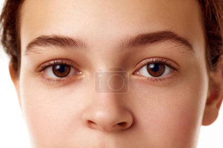 Photo for Close-up image of beautiful young girl with smooth, healthy, well-kept skin, brown eyes standing against white background. Concept of natural female beauty, skin care, cosmetology and cosmetics - Royalty Free Image