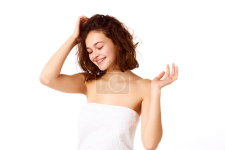 Photo for Beautiful young girl with smooth healthy skin, brown curly short hair standing in shower towel against white background. Concept of natural female beauty, skin care, cosmetology and cosmetics - Royalty Free Image