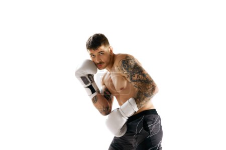 Foto de Protección. Hombre joven musculoso sin camisa, entrenamiento atleta de boxeo aislado sobre fondo blanco. Concepto de deporte profesional, deporte de combate, artes marciales, fuerza - Imagen libre de derechos