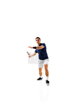 Téléchargez les photos : Image complète du jeune homme, athlète de tennis en mouvement, jouant, pratiquant isolé sur fond blanc. Concept de sport professionnel, compétition, jeu, mathématiques, passe-temps, action - en image libre de droit