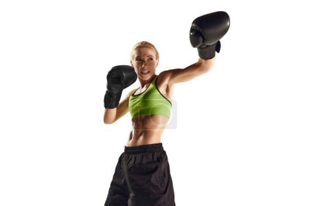 Téléchargez les photos : Poinçon gauche. Jeune femme sportive, athlète de boxe avec un entraînement musculaire mince isolé sur fond blanc. Concept de sport, mode de vie actif et sain, force et endurance, soins corporels - en image libre de droit