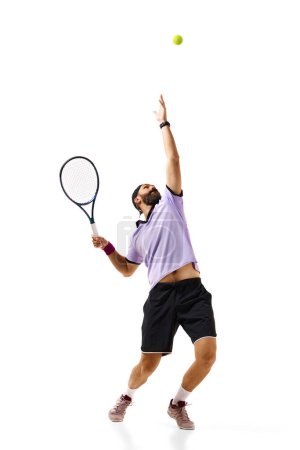 Téléchargez les photos : Image complète de jeune homme athlétique, joueur de tennis en mouvement avec raquette, pratiquant isolé sur fond blanc. Concept de sport professionnel, mouvement, compétition, action. Publicité - en image libre de droit