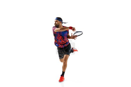 Photo for Bearded young man in colorful uniform raining, playing tennis hitting ball with racket isolated over white studio background. Concept of professional sport, movement, competition, action. Ad - Royalty Free Image