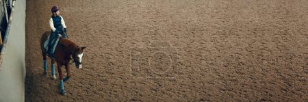 Photo for Little girl, child riding horse, training, practicing horseback riding on special arena. Concept of sport, childhood, school, course, active lifestyle, hobby. Banner. Empty space to insert text - Royalty Free Image