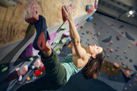 Photo for Young sportive, muscular woman, bouldering instructor training, practicing indoors, climbing wall. Concept of bouldering, sport climbing, hobby, active lifestyle, training course - Royalty Free Image