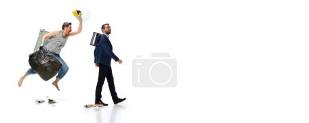Téléchargez les photos : Homme aux pieds nus portant poubelle, ramassant des ordures avec un homme d'affaires marchant isolé sur fond blanc. Concept d'environnement, écologie, protection de la nature, recyclage, sensibilisation - en image libre de droit