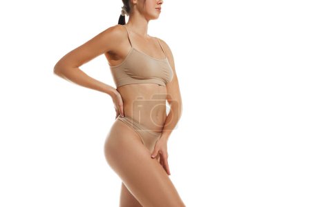 Photo for Cropped side view image of slim, relief female body. Model posing in underwear against white studio background. Concept of natural beauty, female health and body care, medicine, diet - Royalty Free Image