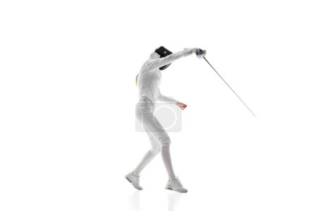 Photo for Self-defense skills. Although sportive, fencing skills can represent the broader theme of self-defense. Female athlete in motion, training over white background. Concept of sport, competition, hobby - Royalty Free Image