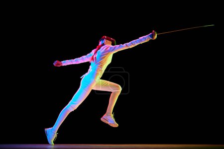 Photo for Action and motion. The dynamic motion of an athlete captured in a high-speed photograph. Female fencer training on black background in neon. Concept of professional sport, competition, championship - Royalty Free Image