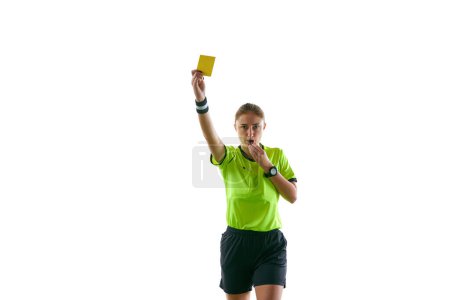 Photo for Serious woman, soccer referee gesturing, raising hand, stopping game and showing yellow card as warning against white studio background. Concept of sport, competition, match, profession, football game - Royalty Free Image
