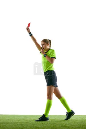 Foto de Mujer seria, árbitro de fútbol gesticulando, levantando la mano, deteniendo el juego y mostrando tarjeta roja contra fondo blanco del estudio. Concepto de deporte, competición, partido, profesión, juego de fútbol, control - Imagen libre de derechos