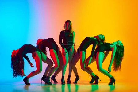 Téléchargez les photos : Jeunes femmes artistiques et expressives en body noir dansant sur des talons hauts sur fond bleu-jaune dégradé au néon. Concept de style de danse moderne, créativité et beauté, art, passe-temps - en image libre de droit