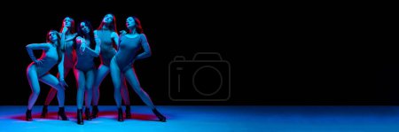 Téléchargez les photos : Club de danse. Les jeunes femmes dansant stiletto dansent, se produisant sur fond noir au néon. Concept de style de danse moderne, créativité et beauté, art, passe-temps. Bannière. Espace vide pour insérer du texte, annonce - en image libre de droit