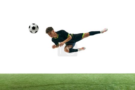 Photo for Dynamic image of young man, football player in motion, hitting ball with head isolated over white background with grass flooring. Concept of sport, game, competition, championship, active lifestyle - Royalty Free Image