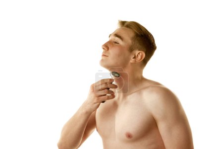 Photo for Face building. Young shirtless man doing face massage with roller isolated over white background. Refreshment. Concept of male beauty, skin care, cosmetology and cosmetics, health - Royalty Free Image