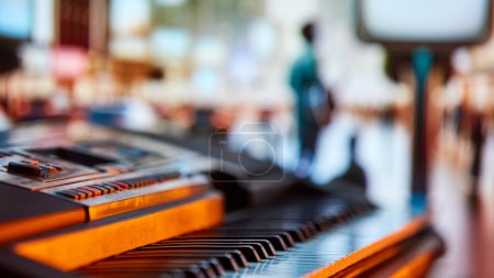 Photo for Piano keyboard close-up with a blurred people on event background. Promotion of offline music concerts. Concept of music instruments, performance, hobby, art, entertainment - Royalty Free Image