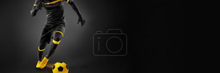 Photo for Cropped image of male soccer playing in motion, dribbling ball over dark background. Yellow elements. Monochrome. Concept of competition, tournament, match, game. Creative design. Banner - Royalty Free Image